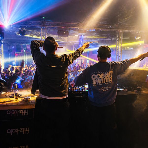 Topmodelz performing live in a club, arms up in front of the crowd.